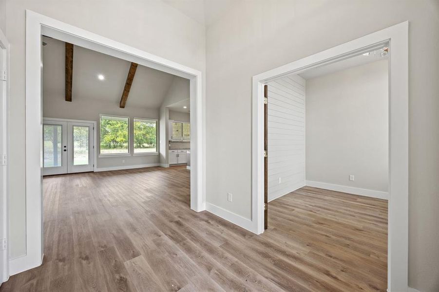 Unfurnished living room with light wood-style floors, french doors, and recessed lighting Unfurnished living room with light wood-style floors, french doors, and recessed lighting