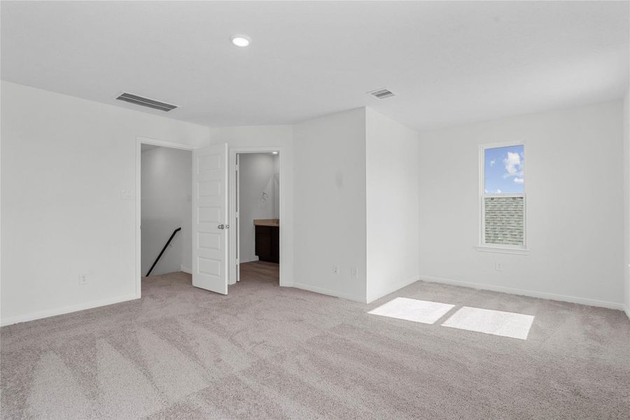 Additional view of primary bedroom highlighting the seating area with window and the entrance to primary bathroom. Additional view of primary bedroom highlighting the seating area with window and the entrance to primary bathroom.