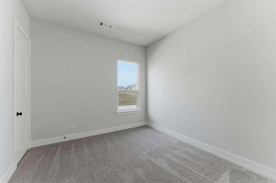 Unfurnished bedroom featuring light colored carpet and baseboards