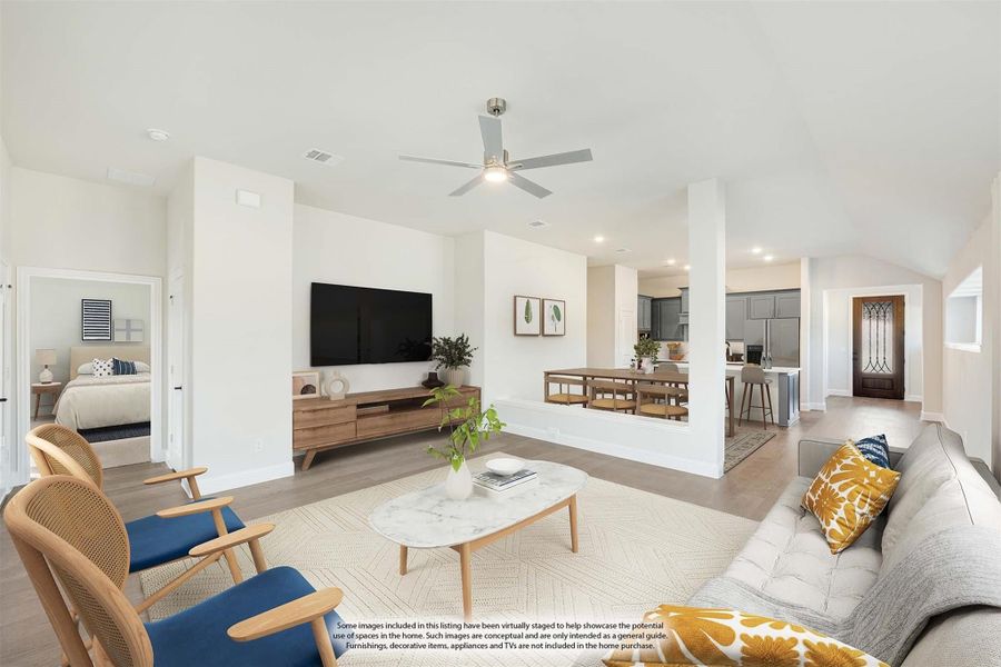 Open living room with ceiling fan, wall-mounted TV, and view into dining area and kitchen
