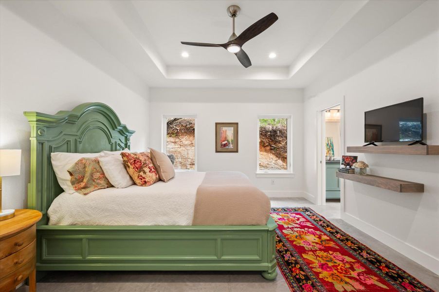Primary Bedroom with a vaulted ceiling, custom floating shelves and big bright framed windows that fully crank open to let the outside inside