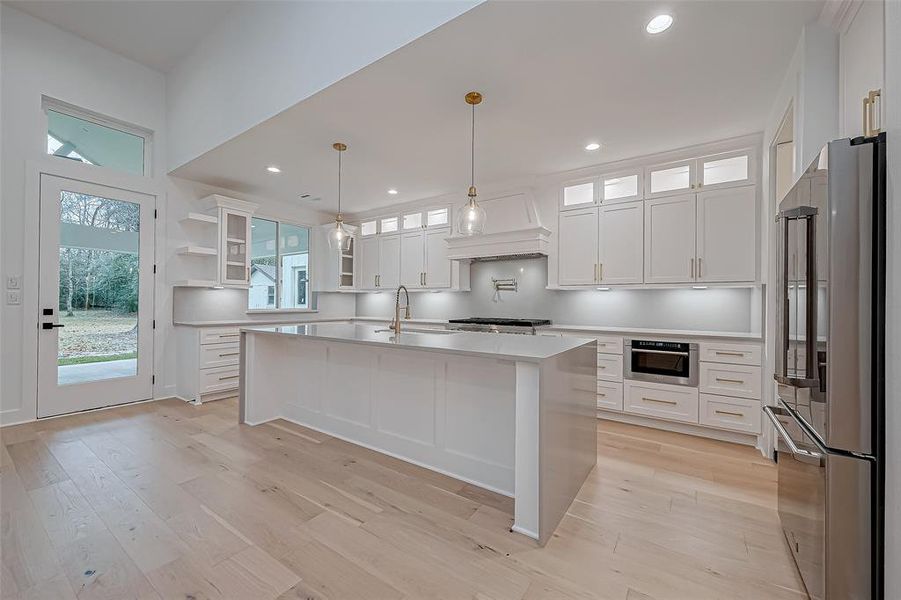 Kitchen with lots of cabinetry, and a spacious island. It includes stainless steel appliances, ample natural light, and a views of the backyard