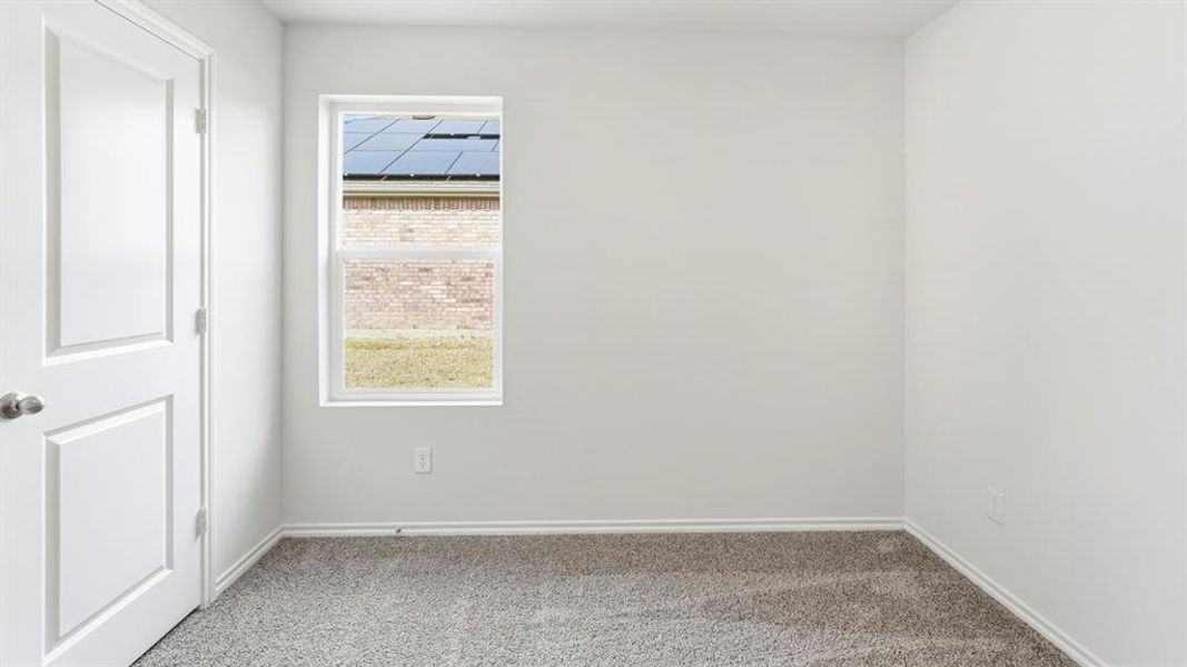 Spare room with light colored carpet and baseboards Spare room with light colored carpet and baseboards