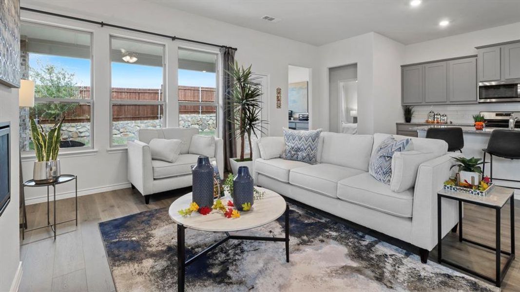 Living room featuring a glass covered fireplace, light wood-type flooring, and recessed lighting
