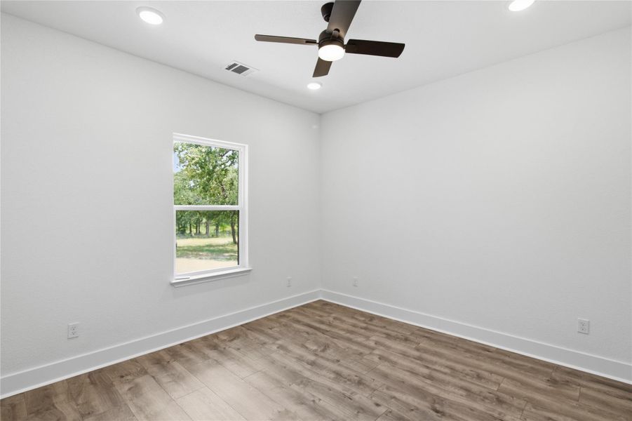 A well-lit bedroom with modern wood flooring and a refreshing view of nature. A well-lit bedroom with modern wood flooring and a refreshing view of nature.
