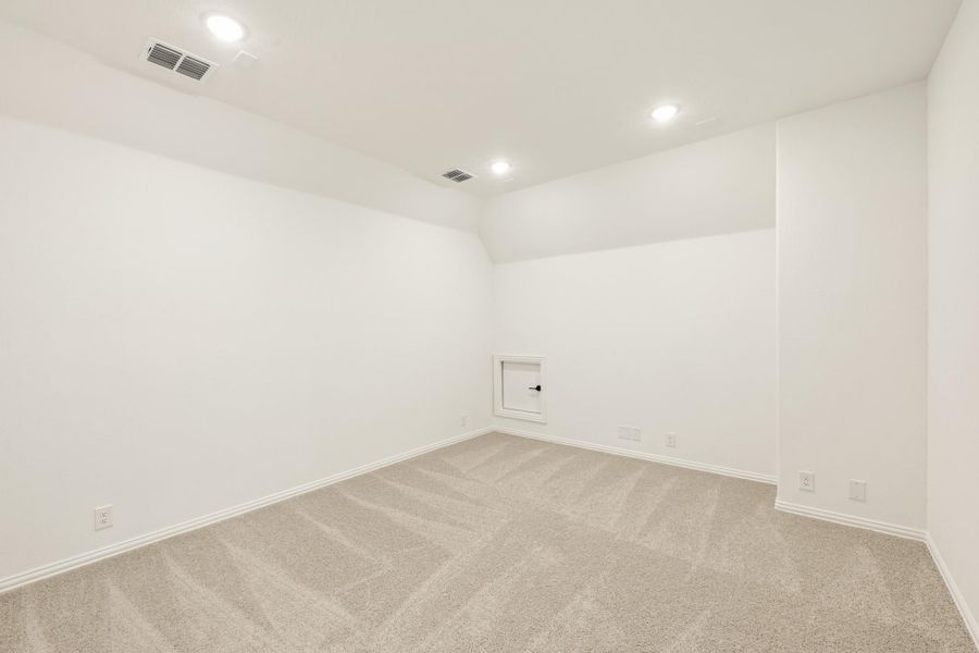 Empty room with white walls, beige carpet, recessed lighting, and a small access door on the wall