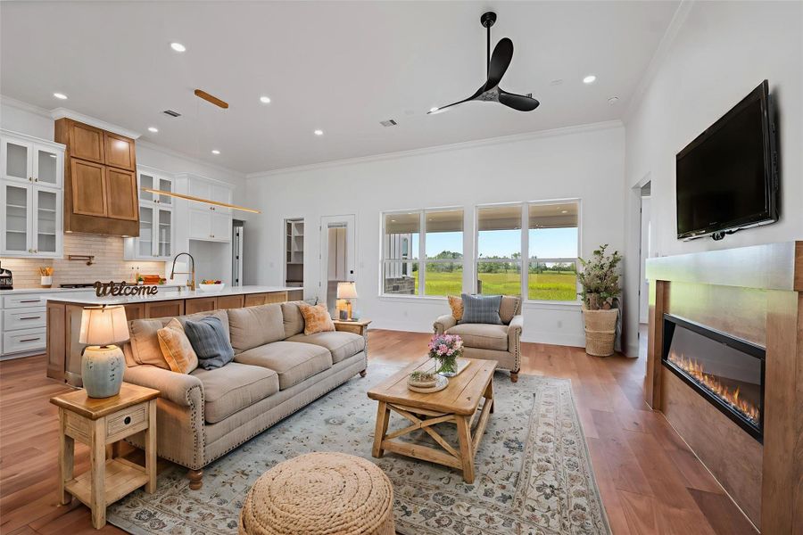 Step into a bright and inviting living space featuring an elegant open layout, cozy fireplace, and stunning views through expansive windows. Perfect for comfortable living and entertaining. DIGITALLY STAGED