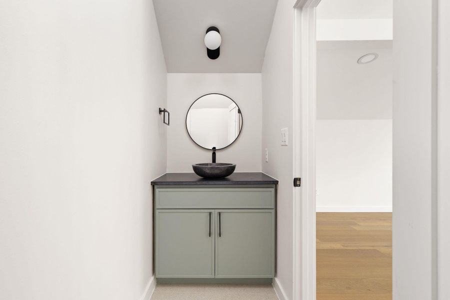 A refined powder room with modern vanity and vessel sink offers understated elegance.