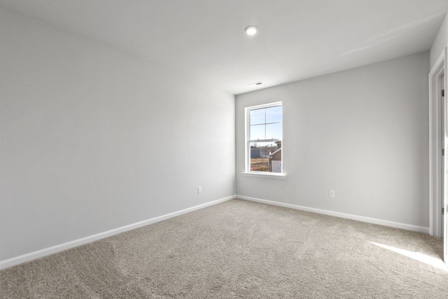 A room with a window and carpet.