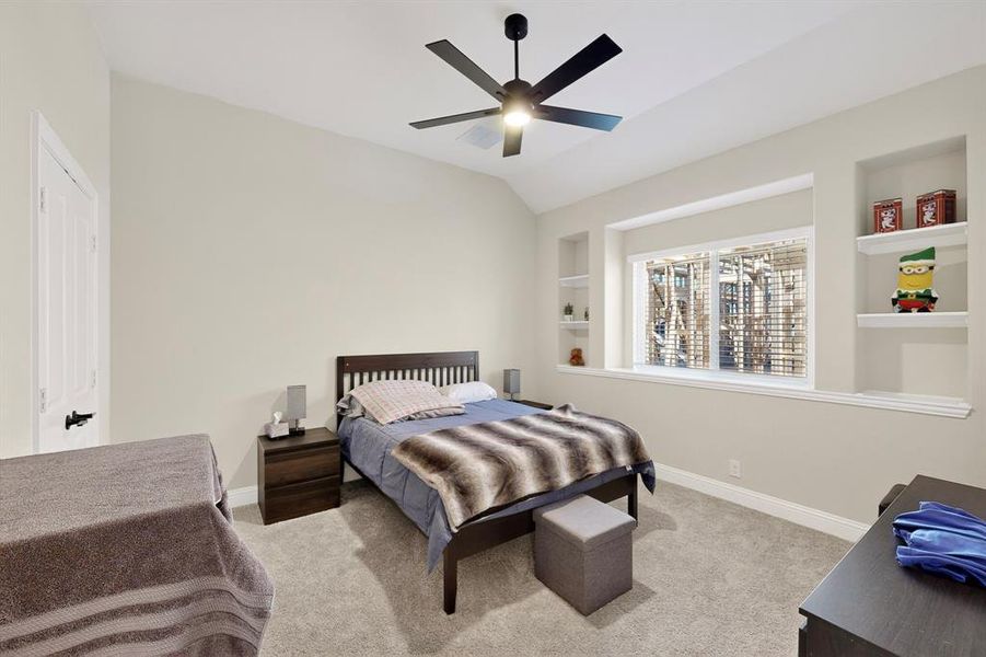 Carpeted bedroom with a ceiling fan and lofted ceiling Carpeted bedroom with a ceiling fan and lofted ceiling