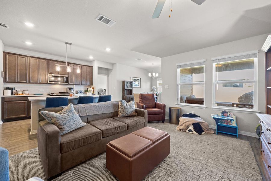 Living room with light wood finished floors, a ceiling fan, recessed lighting, and a chandelier Living room with light wood finished floors, a ceiling fan, recessed lighting, and a chandelier