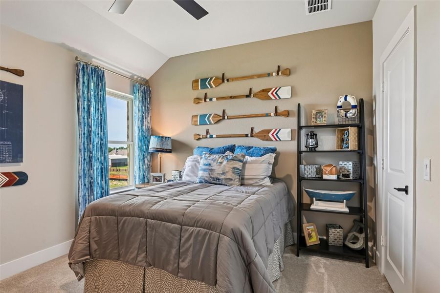 Bedroom with nautical decor, decorative oars on wall, gray bedding, and black shelving unit Bedroom with nautical decor, decorative oars on wall, gray bedding, and black shelving unit