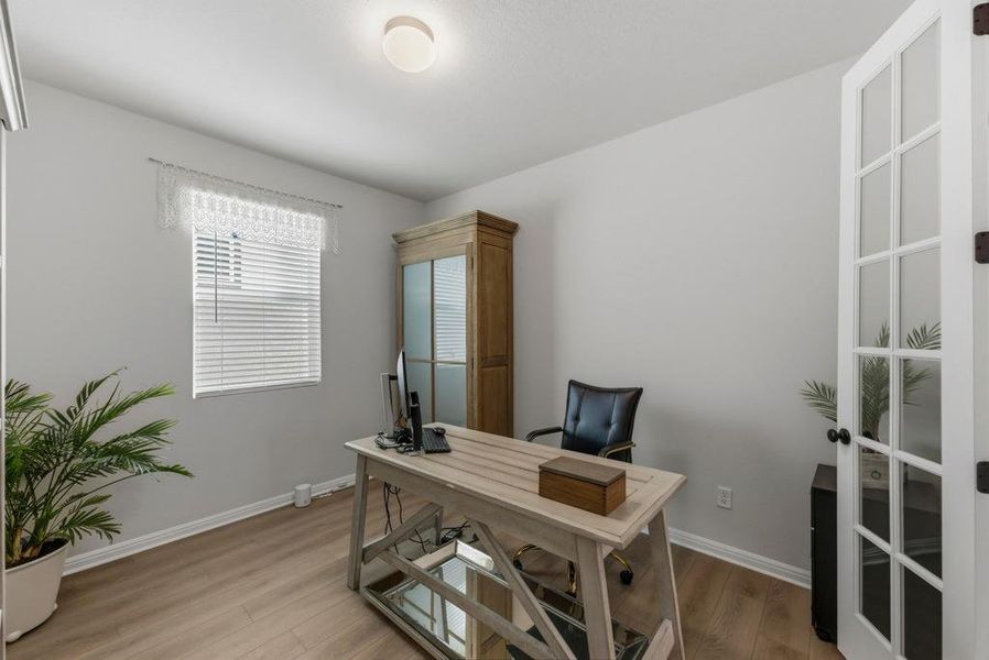 Office space with light wood-style flooring and baseboards