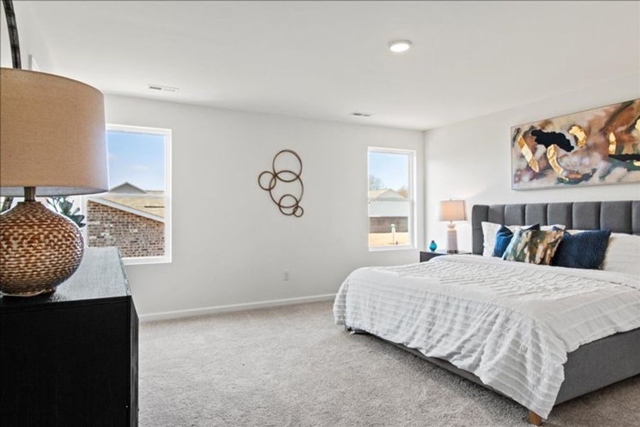 A bedroom with a bed and a lamp.