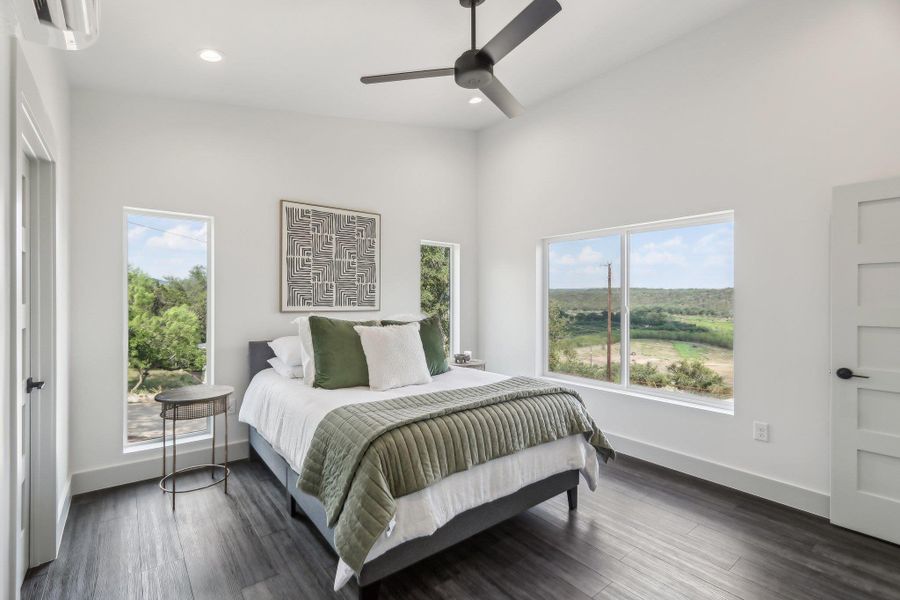 Bedroom with recessed lighting, baseboards, dark wood-type flooring, ceiling fan, and a high ceiling Bedroom with recessed lighting, baseboards, dark wood-type flooring, ceiling fan, and a high ceiling