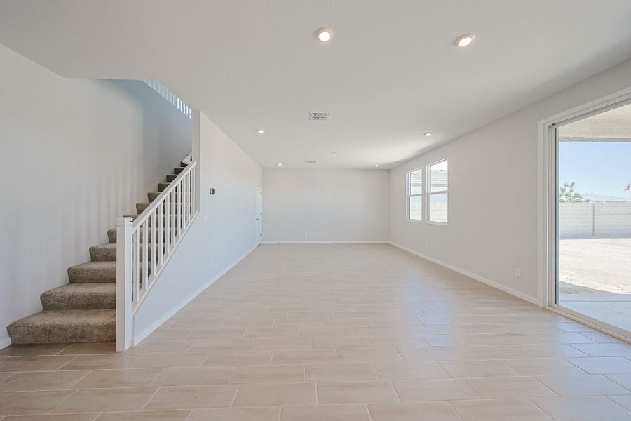 A large white room with a glass door and a white staircase. A large white room with a glass door and a white staircase.