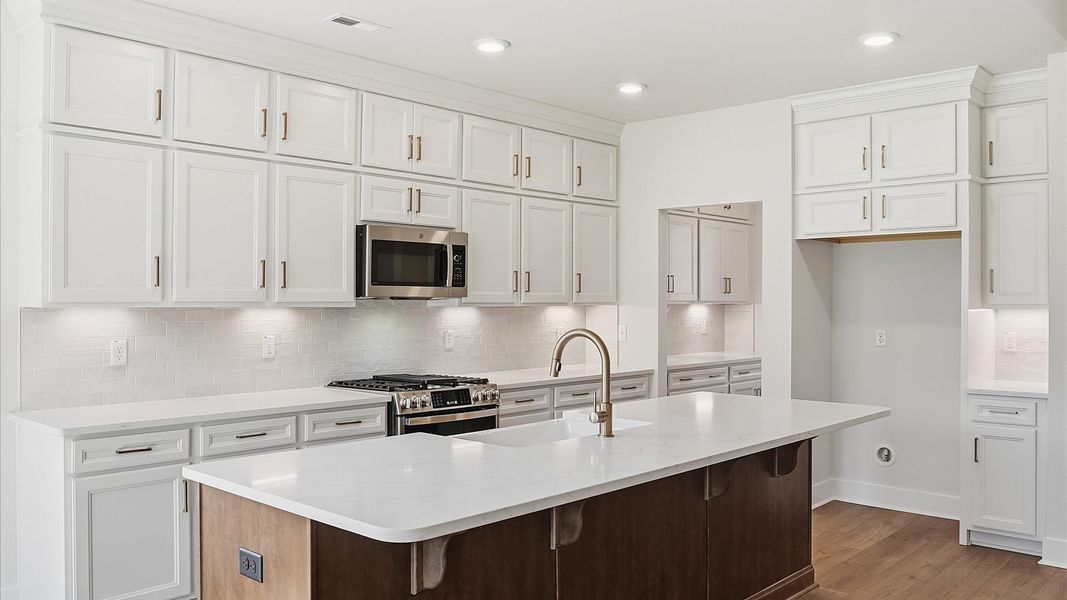 Superior kitchen with quartz countertops, white cabinets, and a generously sized island in Woodruff, SC Superior kitchen with quartz countertops, white cabinets, and a generously sized island in Woodruff, SC