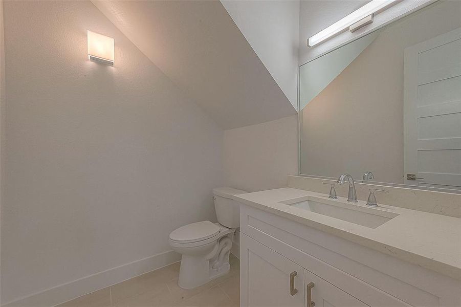 The powder room has 2x1' tile flooring, rectangular undermount sink, Quartz countertop, Glacier Bay polished nickel hardware, and bath bar vanity light.