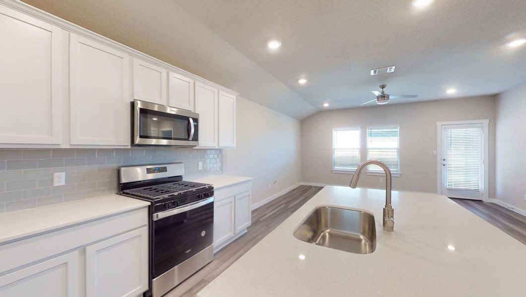 Kitchen featuring stainless steel appliances, white cabinets, recessed lighting, tasteful backsplash, and light wood-style flooring