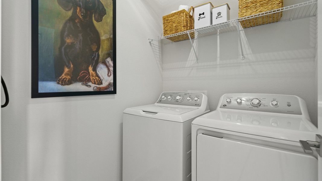 The Atlantic’s laundry room includes a washer and dryer setup, storage shelf, and decorative touches for functional style.