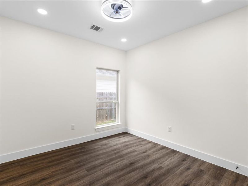 Empty room featuring dark wood finished floors and recessed lighting
