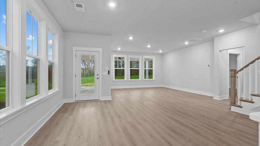 Spacious family room with rich hardwood flooring and elegant trim work in a reputable DRB Homes build Spacious family room with rich hardwood flooring and elegant trim work in a reputable DRB Homes build