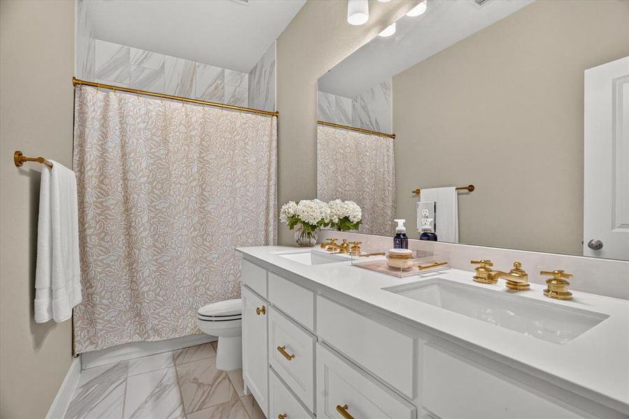 Bathroom featuring a double vanity with white cabinetry and integrated sinks Bathroom featuring a double vanity with white cabinetry and integrated sinks