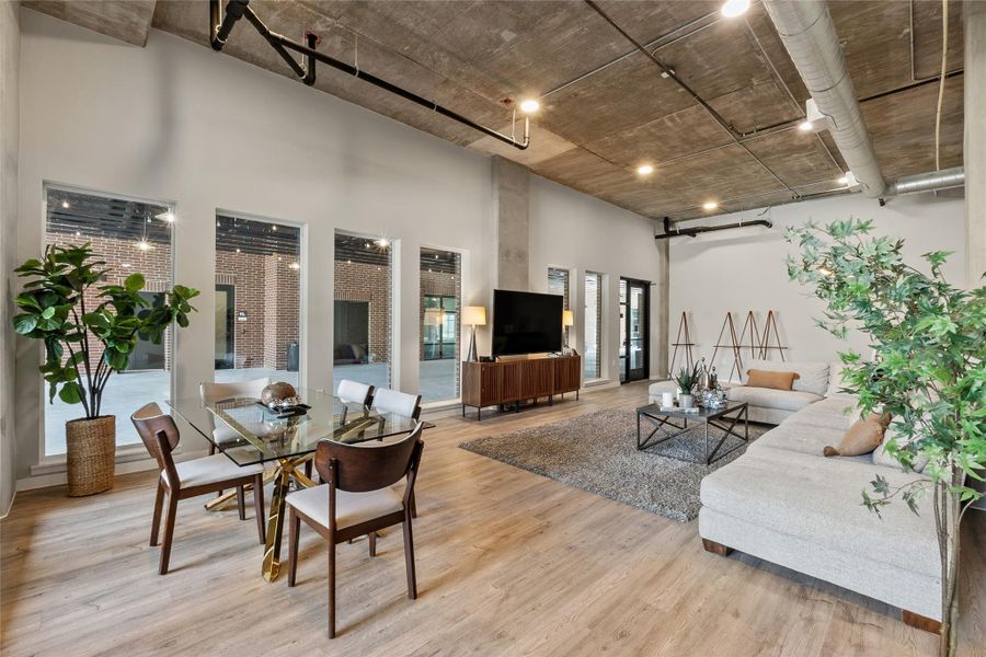 Living room featuring light wood-style floors, a high ceiling, and a barn door