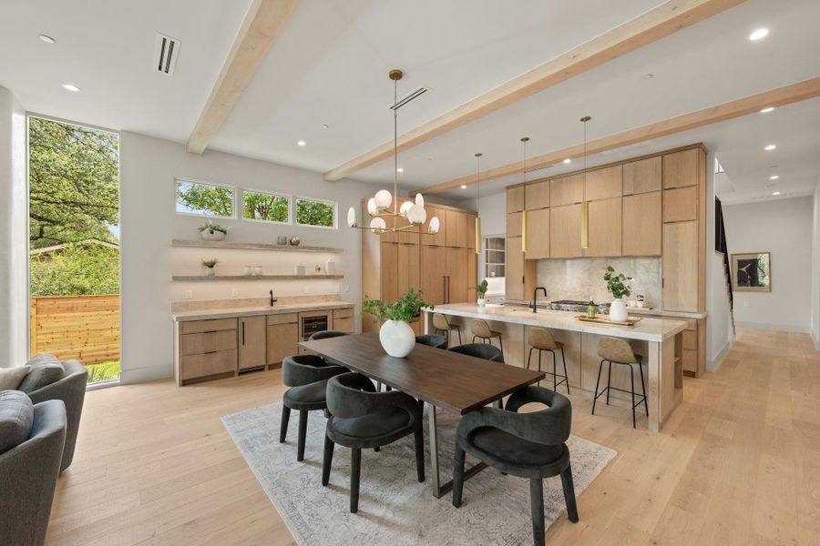 Blonde hardwood floors extend across this naturally illuminated, open-concept kitchen and dining area. Blonde hardwood floors extend across this naturally illuminated, open-concept kitchen and dining area.