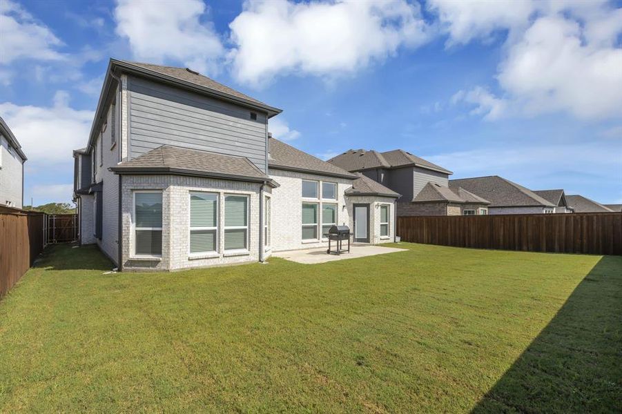 Back of property featuring a patio and a yard