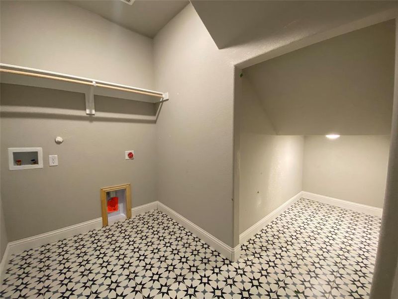Utility room has designer decorative tile and extra storage under the stairs