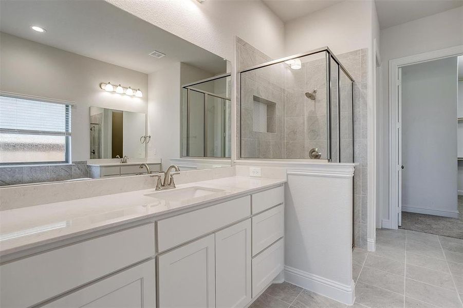 Bathroom with tile patterned flooring, walk in shower, and vanity