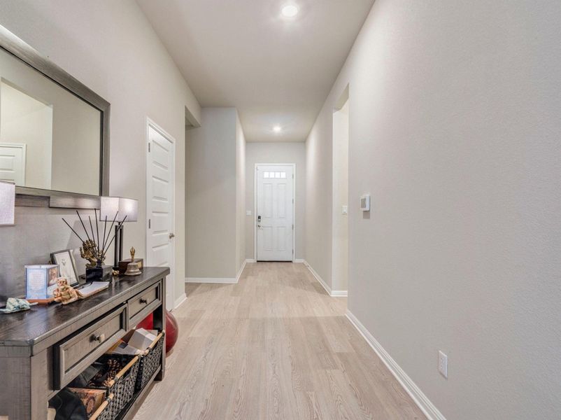 A well-lit entry hall with light-toned flooring guides visitors to the main entrance. Storage, garage, laundry and bedrooms featured along this corridor. Dedicated office tucked away for privacy.