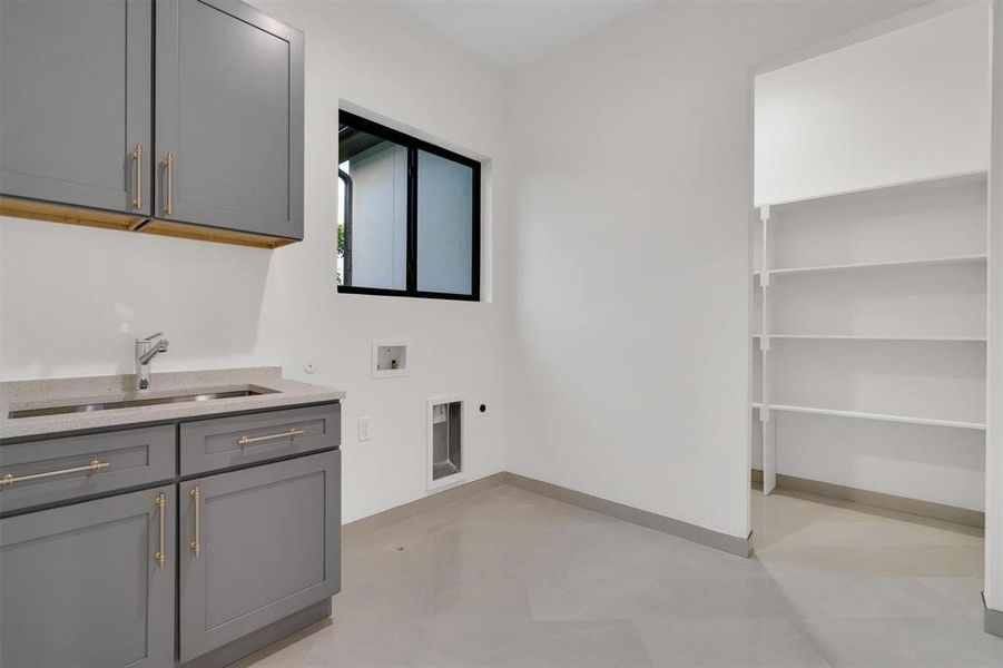 Laundry area with hookup for a washing machine, electric dryer hookup, and cabinet space