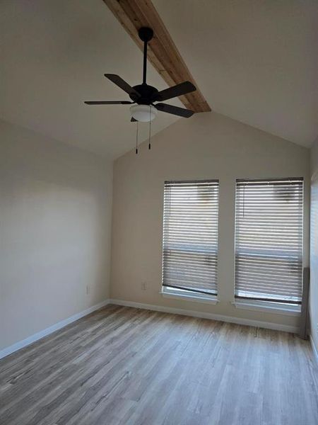 Empty room with beamed ceiling, light wood-type flooring, and ceiling fan Empty room with beamed ceiling, light wood-type flooring, and ceiling fan