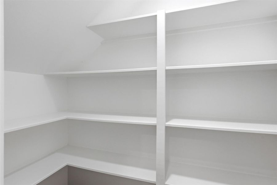 Spacious walk in pantry with custom built in shelving on two walls — plenty of storage space!