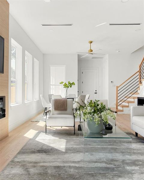 Living room featuring a healthy amount of sunlight, wood-type flooring, and ceiling fan