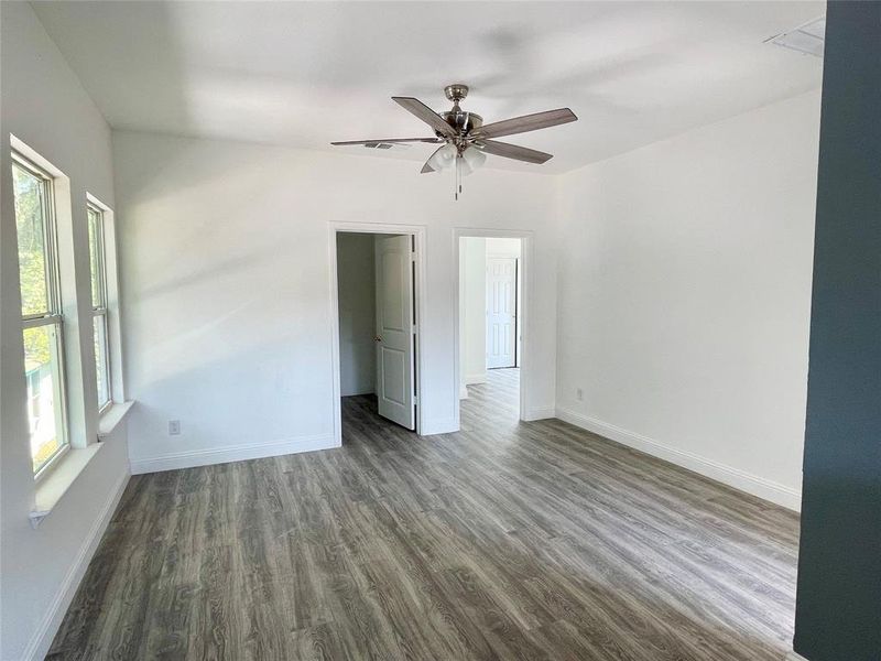 Unfurnished bedroom with ceiling fan and dark hardwood / wood-style floors