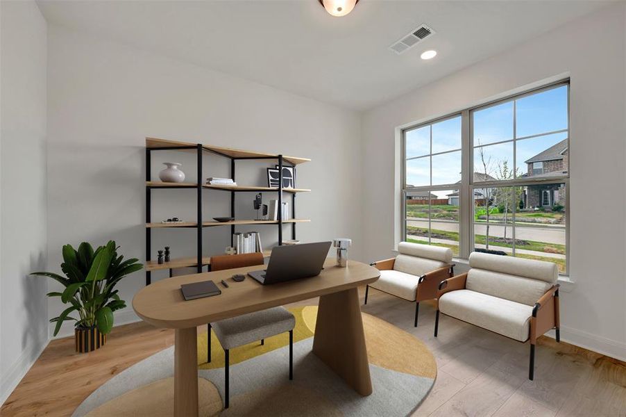 Office space featuring light wood finished floors and recessed lighting