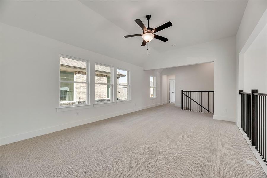 Spare room with light carpet, vaulted ceiling, and ceiling fan