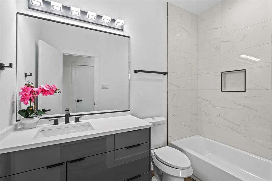 Full bathroom with vanity, toilet, and tiled shower / bath