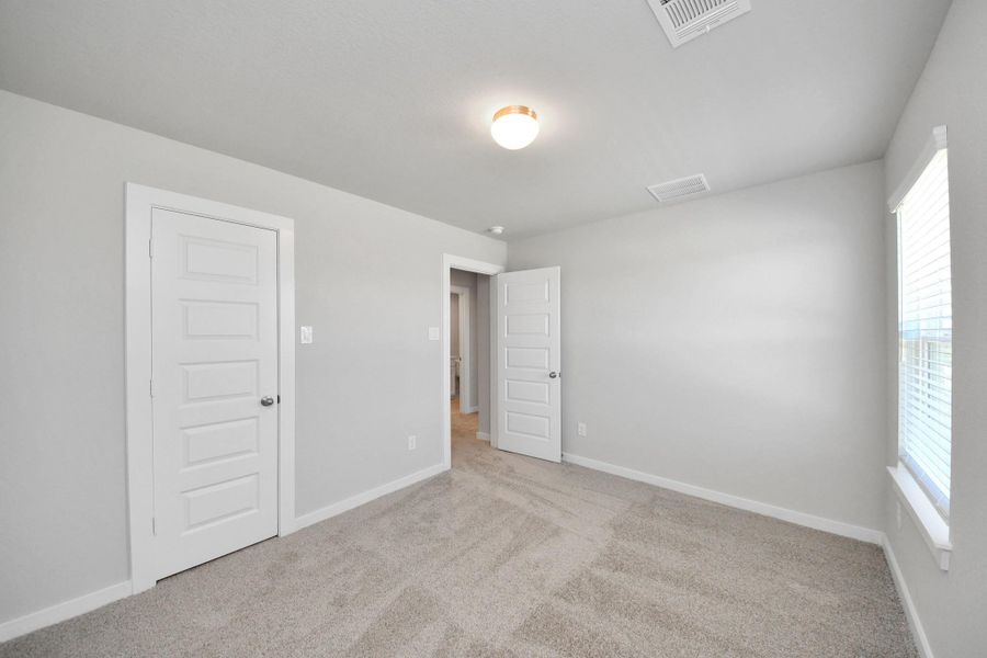 Generously sized secondary bedrooms featuring spacious closets, soft and inviting carpeting underfoot, large windows allowing plenty of natural light, and the added touch of privacy blinds for your personal retreat. Sample photo of completed home with similar floor plan. Actual colors and selections may vary. Generously sized secondary bedrooms featuring spacious closets, soft and inviting carpeting underfoot, large windows allowing plenty of natural light, and the added touch of privacy blinds for your personal retreat. Sample photo of completed home with similar floor plan. Actual colors and selections may vary.