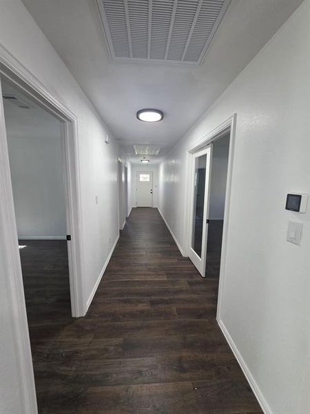 Hallway with attic access and dark wood-style flooring Hallway with attic access and dark wood-style flooring