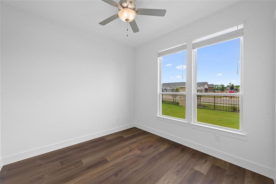 Bright interior space featuring wood-finish flooring, white walls, and a ceiling fan