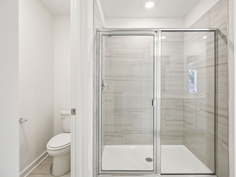 The primary bathroom offers dual vanity sinks and a walk-in shower.