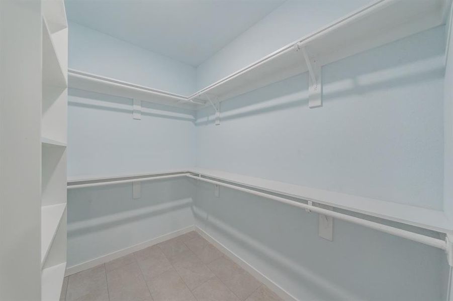 Walk in closet with light tile patterned floors Walk in closet with light tile patterned floors