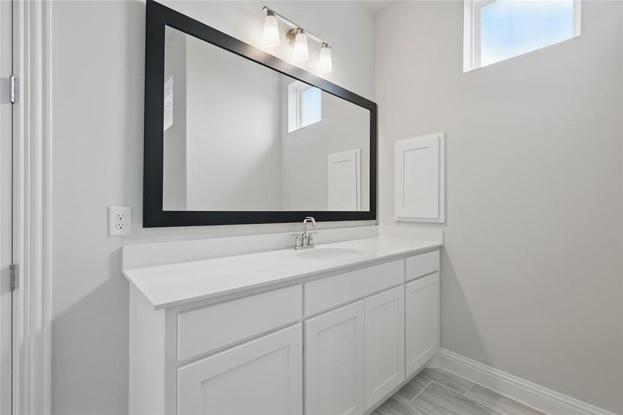 Bathroom featuring baseboards and vanity Bathroom featuring baseboards and vanity