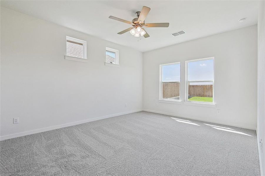 Carpeted spare room with ceiling fan