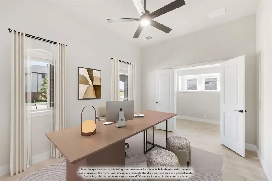 Home office with wood desk, ceiling fan, and light hardwood floors