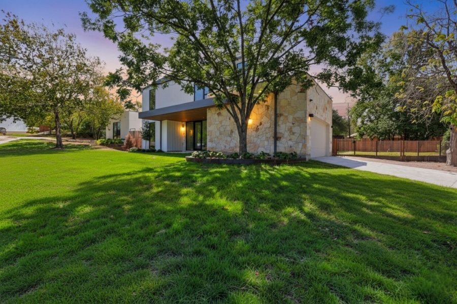 View of front of property with stone siding, concrete driveway, and a garage View of front of property with stone siding, concrete driveway, and a garage